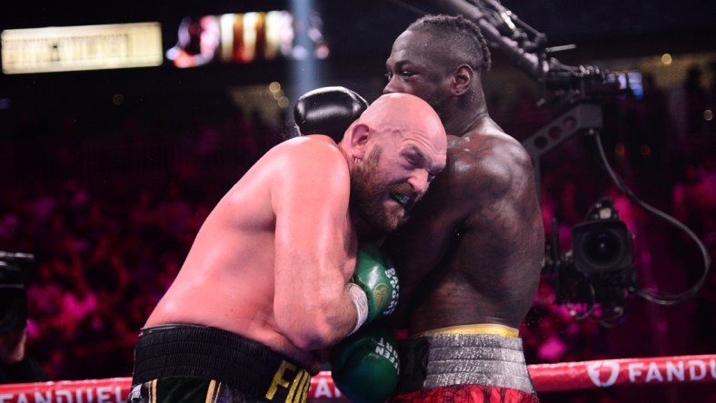 Oct 9, 2021; Las Vegas, Nevada, USA; Deontay Wilder (red/black trunks) and Tyson Fury (black/gold trunks) box during their WBC/Lineal heavyweight championship boxing match at T-Mobile Arena. Mandatory Credit: Joe Camporeale-USA TODAY Sports