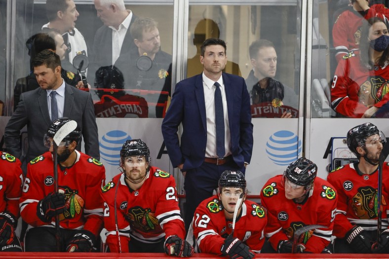 Oct 21, 2021; Chicago, Illinois, USA; Chicago Blackhawks head coach Jeremy Colliton looks on from the bench during the first period of a NHL game against the Vancouver Canucks at United Center. Mandatory Credit: Kamil Krzaczynski-USA TODAY Sports