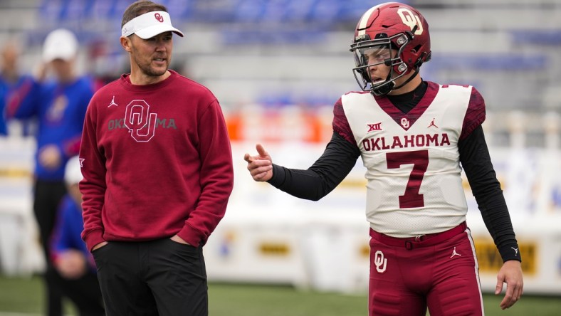 Oct 23, 2021; Lawrence, Kansas, USA; Oklahoma Sooners quarterback Spencer Rattler (7) talks with head coach Lincoln Riley before the game against the Kansas Jayhawks at David Booth Kansas Memorial Stadium. Mandatory Credit: Jay Biggerstaff-USA TODAY Sports