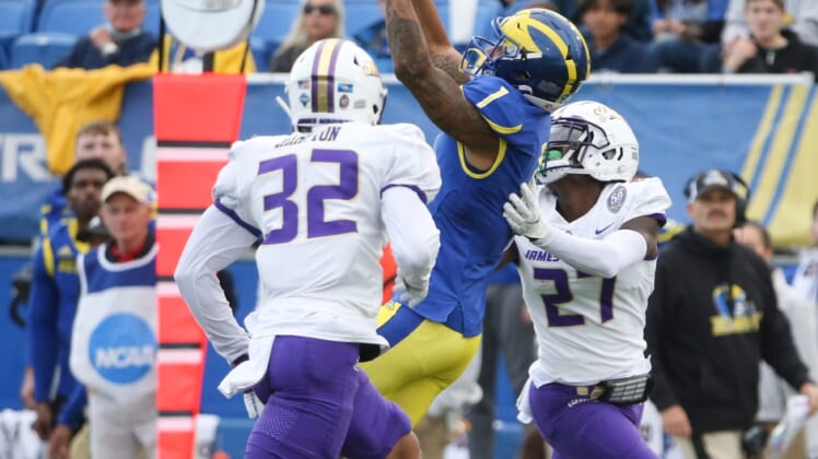 Delaware receiver Thyrick Pitts (1) pulls in a pass between James Madison's MJ Hampton (32) and Taurus Carroll in the second quarter at Delaware Stadium, Saturday, Oct. 23, 2021.Ud V Jmu