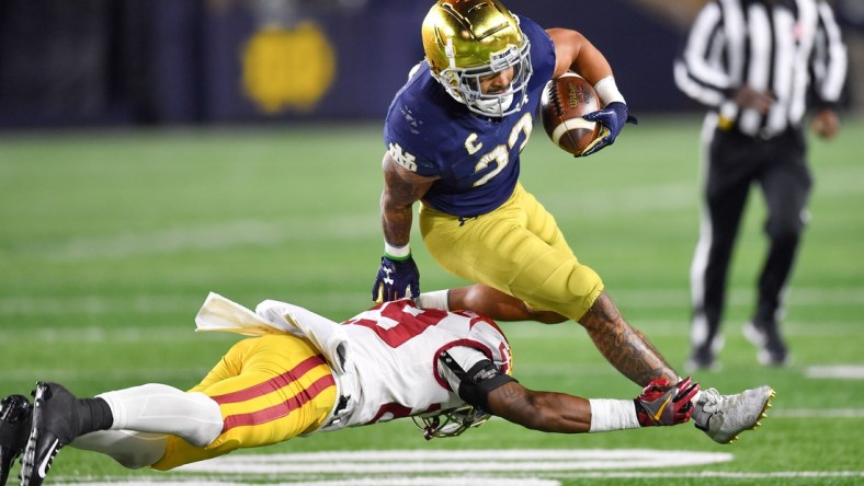 Oct 23, 2021; South Bend, Indiana, USA; Notre Dame Fighting Irish running back Kyren Williams (23) runs the ball as USC Trojans safety Xavion Alford (29) defends in the third quarter at Notre Dame Stadium. Mandatory Credit: Matt Cashore-USA TODAY Sports