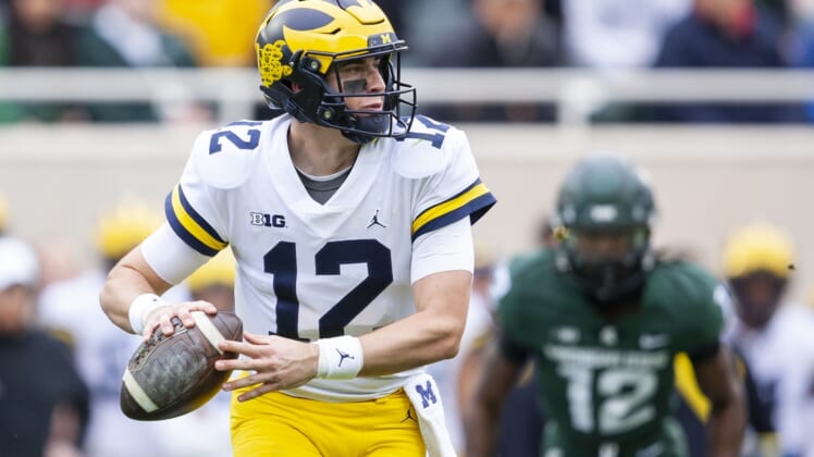 Oct 30, 2021; East Lansing, Michigan, USA; Michigan Wolverines quarterback Cade McNamara (12) looks to pass the ball during the first quarter against the Michigan State Spartans at Spartan Stadium. Mandatory Credit: Raj Mehta-USA TODAY Sports