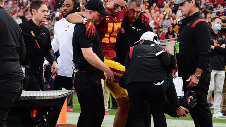 Oct 30, 2021; Los Angeles, California, USA; Southern California Trojans wide receiver Drake London (15) is helped off the field after suffering an injury against the Arizona Wildcats during the first half at United Airlines Field at Los Angeles Memorial Coliseum. Mandatory Credit: Gary A. Vasquez-USA TODAY Sports