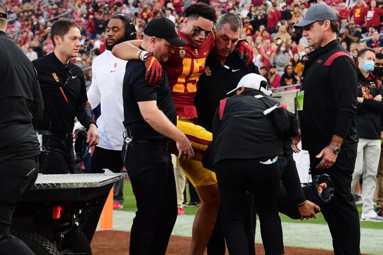 Oct 30, 2021; Los Angeles, California, USA; Southern California Trojans wide receiver Drake London (15) is helped off the field after suffering an injury against the Arizona Wildcats during the first half at United Airlines Field at Los Angeles Memorial Coliseum. Mandatory Credit: Gary A. Vasquez-USA TODAY Sports