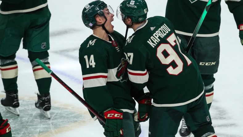 Nov 2, 2021; Saint Paul, Minnesota, USA; Minnesota Wild center Joel Eriksson Ek (14) celebrates with left wing Kirill Kaprizov (97) after Kaprizov scored a goal against the Ottawa Senators in overtime at Xcel Energy Center. Mandatory Credit: David Berding-USA TODAY Sports