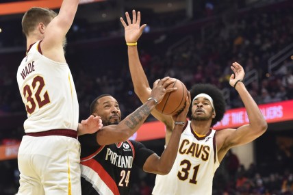Nov 3, 2021; Cleveland, Ohio, USA; Portland Trail Blazers forward Norman Powell (24) drives between Cleveland Cavaliers forward Dean Wade (32) and center Jarrett Allen (31) in the second quarter at Rocket Mortgage FieldHouse. Mandatory Credit: David Richard-USA TODAY Sports