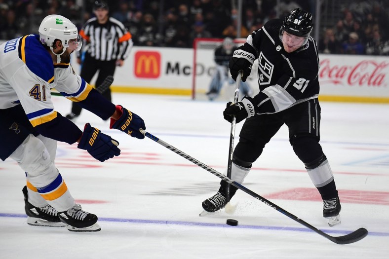 Nov 3, 2021; Los Angeles, California, USA; Los Angeles Kings left wing Carl Grundstrom (91) shoots against the defense of St. Louis Blues defenseman Robert Bortuzzo (41) during the second period at Staples Center. Mandatory Credit: Gary A. Vasquez-USA TODAY Sports
