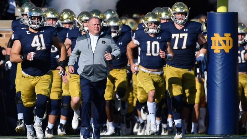 Nov 6, 2021; South Bend, Indiana, USA; Notre Dame Fighting Irish head coach Brian Kelly leads players onto the field before the game against the Navy Midshipmen at Notre Dame Stadium. Mandatory Credit: Matt Cashore-USA TODAY Sports