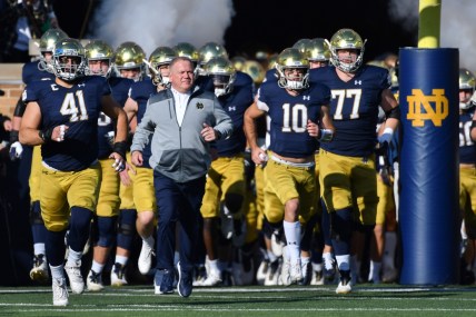 Nov 6, 2021; South Bend, Indiana, USA; Notre Dame Fighting Irish head coach Brian Kelly leads players onto the field before the game against the Navy Midshipmen at Notre Dame Stadium. Mandatory Credit: Matt Cashore-USA TODAY Sports