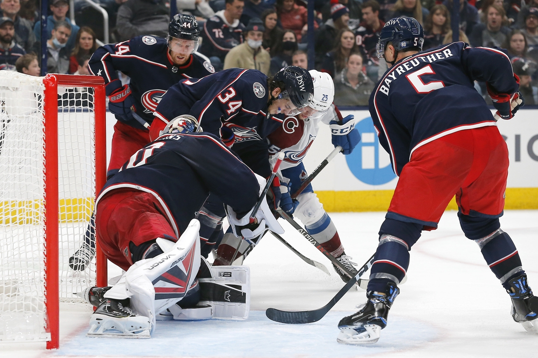 Nov 6, 2021; Columbus, Ohio, USA; Columbus Blue Jackets center Cole Sillinger (34) and Colorado Avalanche right wing Logan O'Connor (25) battle for a loose puck during the third period at Nationwide Arena. Mandatory Credit: Russell LaBounty-USA TODAY Sports