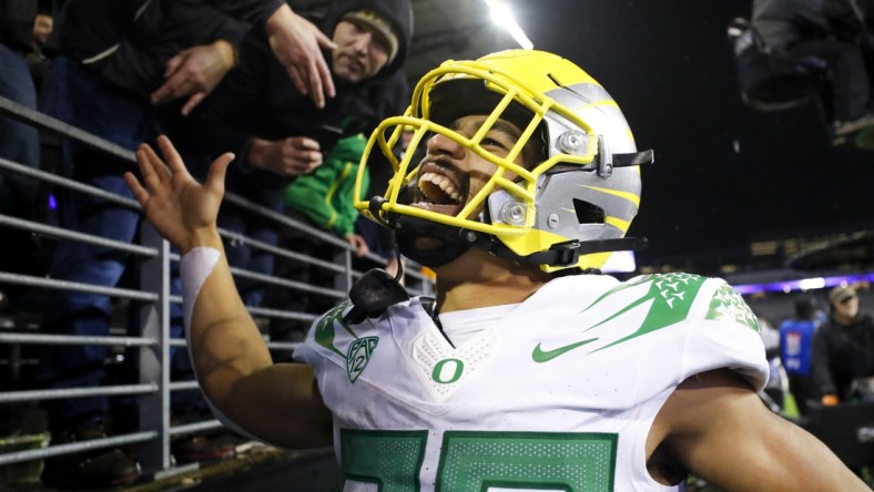 Nov 6, 2021; Seattle, Washington, USA; Oregon Ducks running back Travis Dye (26) celebrates with fans following a 26-16 victory against the Washington Huskies at Alaska Airlines Field at Husky Stadium. Mandatory Credit: Joe Nicholson-USA TODAY Sports