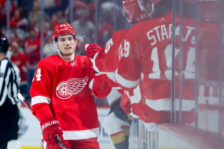 Nov 7, 2021; Detroit, Michigan, USA;  Detroit Red Wings center Pius Suter (24) receives congratulations from teammates after scoring in the first period against the Vegas Golden Knights at Little Caesars Arena. Mandatory Credit: Rick Osentoski-USA TODAY Sports