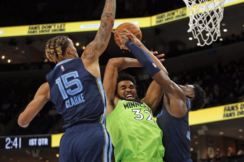 Nov 8, 2021; Memphis, Tennessee, USA; Minnesota Timberwolves center/forward Karl-Anthony Towns (32) fights for control of a rebound with Memphis Grizzles forward Jaren Jackson Jr. (13) during the first half at FedExForum. Mandatory Credit: Petre Thomas-USA TODAY Sports