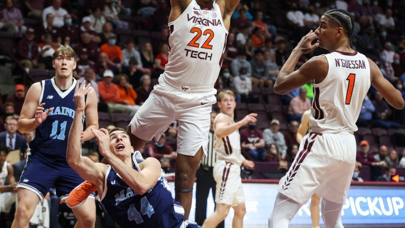 Nov 9, 2021; Blacksburg, Virginia, USA; Maine Black Bears forward Peter Filipovity (44) tosses up a shot guarded by Virginia Tech Hokies forward Keve Aluma (22) at Cassell Coliseum. Mandatory Credit: Ryan Hunt-USA TODAY Sports