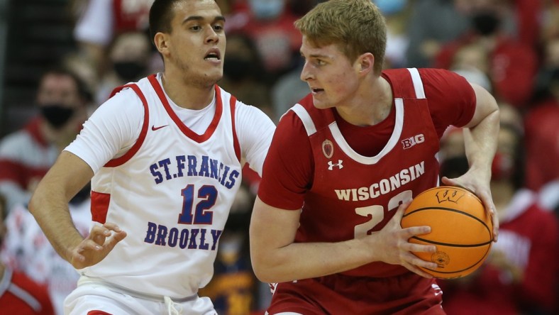 Nov 9, 2021; Madison, Wisconsin, USA; Wisconsin Badgers forward Steven Crowl (22) works the ball against St. Francis Terriers forward Vuk Stevanic (12) at the Kohl Center. Mandatory Credit: Mary Langenfeld-USA TODAY Sports