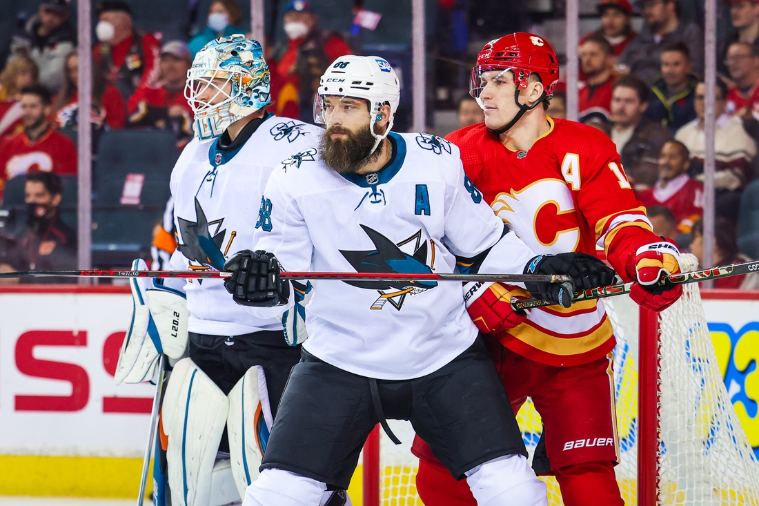 Nov 9, 2021; Calgary, Alberta, CAN; San Jose Sharks defenseman Brent Burns (88) and Calgary Flames left wing Matthew Tkachuk (19) fight for position in front of San Jose Sharks goaltender Adin Hill (33) during the first period at Scotiabank Saddledome. Mandatory Credit: Sergei Belski-USA TODAY Sports