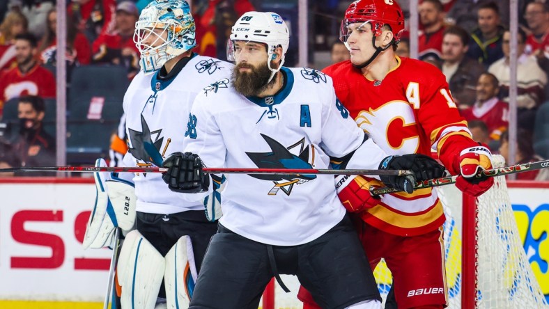 Nov 9, 2021; Calgary, Alberta, CAN; San Jose Sharks defenseman Brent Burns (88) and Calgary Flames left wing Matthew Tkachuk (19) fight for position in front of San Jose Sharks goaltender Adin Hill (33) during the first period at Scotiabank Saddledome. Mandatory Credit: Sergei Belski-USA TODAY Sports