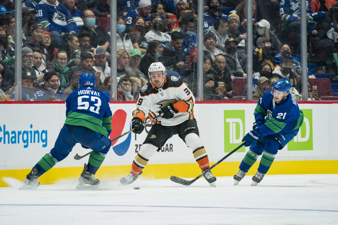 Nov 9, 2021; Vancouver, British Columbia, CAN; Vancouver Canucks forward Bo Horvat (53) and forward Nils Hoglander (21) check Anaheim Ducks forward Sam Carrick (39) in the second period at Rogers Arena. Mandatory Credit: Bob Frid-USA TODAY Sports