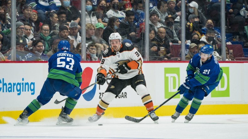 Nov 9, 2021; Vancouver, British Columbia, CAN; Vancouver Canucks forward Bo Horvat (53) and forward Nils Hoglander (21) check Anaheim Ducks forward Sam Carrick (39) in the second period at Rogers Arena. Mandatory Credit: Bob Frid-USA TODAY Sports