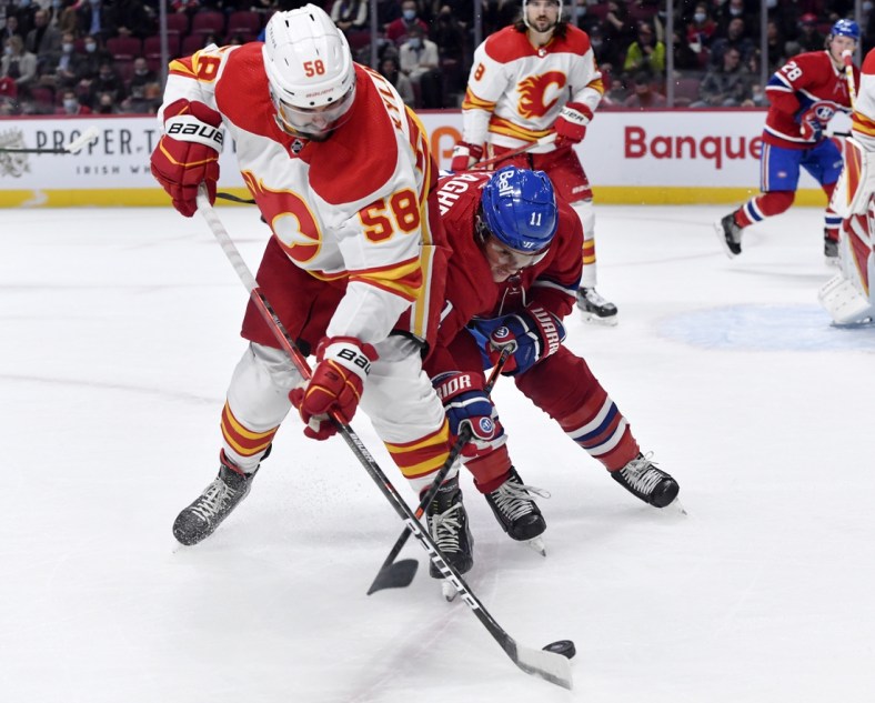 Nov 11, 2021; Montreal, Quebec, CAN; Calgary Flames defenseman Oliver Kylington (58) and Montreal Canadiens forward Brendan Gallagher (11) battle for the puck during the first period at the Bell Centre. Mandatory Credit: Eric Bolte-USA TODAY Sports