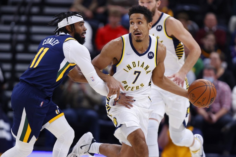 Nov 11, 2021; Salt Lake City, Utah, USA; Indiana Pacers guard Malcolm Brogdon (7) looks to pass against Utah Jazz guard Mike Conley (11) in the first quarter at Vivint Arena. Mandatory Credit: Jeffrey Swinger-USA TODAY Sports