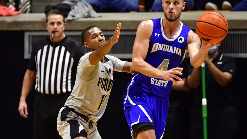 Nov 12, 2021; West Lafayette, Indiana, USA; Indiana State Sycamores guard Cooper Neese (4) passes the ball away from Purdue Boilermakers guard Isaiah Thompson (11) during the second half at Mackey Arena. Purdue won 92-67.  Mandatory Credit: Marc Lebryk-USA TODAY Sports