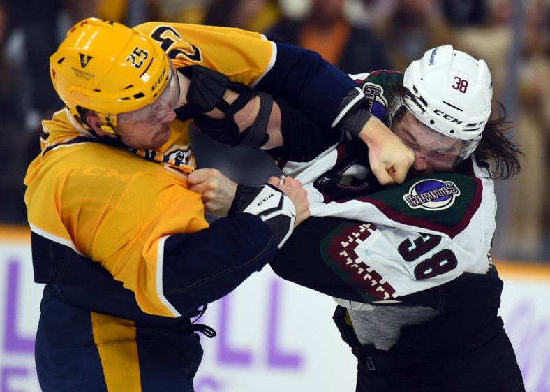 Nov 13, 2021; Nashville, Tennessee, USA; Arizona Coyotes center Liam 0'Brien (38) and Nashville Predators right wing Mathieu Olivier (25) fight during the first period at Bridgestone Arena. Mandatory Credit: Christopher Hanewinckel-USA TODAY Sports