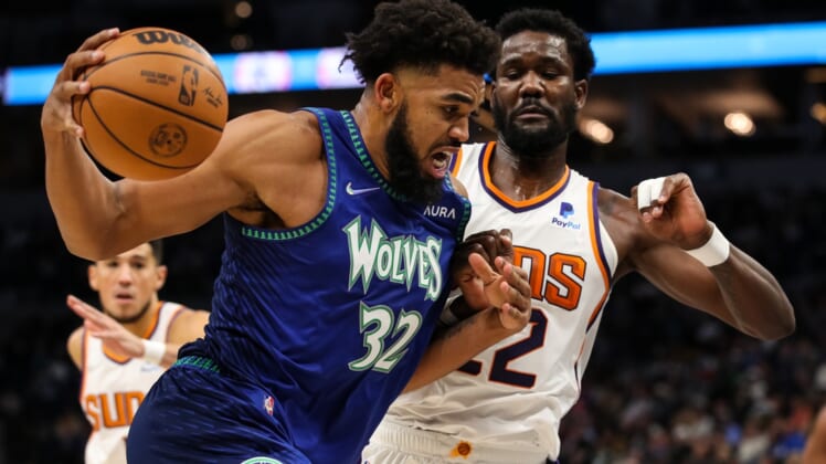 Nov 15, 2021; Minneapolis, Minnesota, USA; Minnesota Timberwolves center Karl-Anthony Towns (32) drives to the basket while Phoenix Suns center Deandre Ayton (22) defends in the first half at Target Center. Mandatory Credit: David Berding-USA TODAY Sports