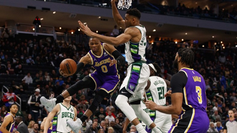 Nov 17, 2021; Milwaukee, Wisconsin, USA;  Los Angeles Lakers guard Russell Westbrook (0) passes the ball around Milwaukee Bucks forward Giannis Antetokounmpo (34) during the first quarter at Fiserv Forum. Mandatory Credit: Jeff Hanisch-USA TODAY Sports