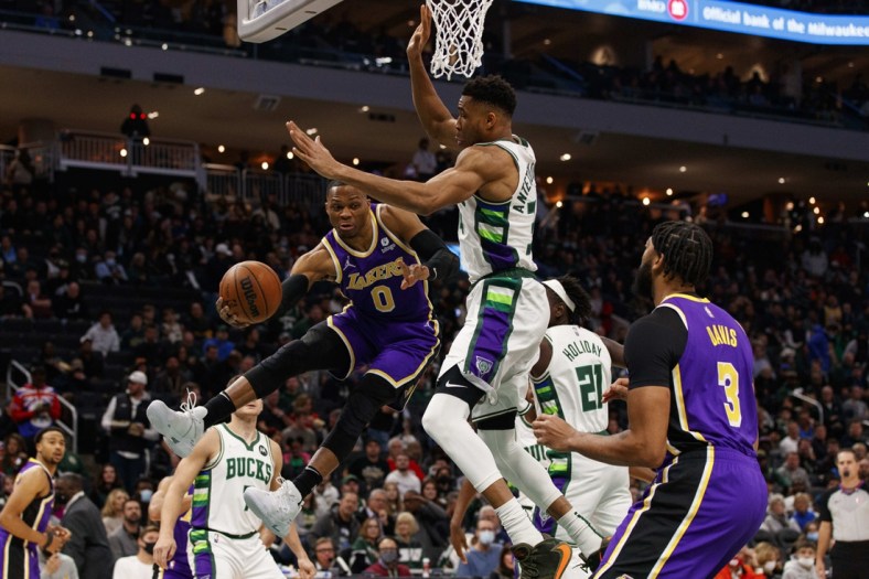 Nov 17, 2021; Milwaukee, Wisconsin, USA;  Los Angeles Lakers guard Russell Westbrook (0) passes the ball around Milwaukee Bucks forward Giannis Antetokounmpo (34) during the first quarter at Fiserv Forum. Mandatory Credit: Jeff Hanisch-USA TODAY Sports