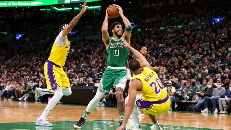 Nov 19, 2021; Boston, Massachusetts, USA; Boston Celtics forward Jayson Tatum (0) drives to the basket defended by Los Angeles Lakers guard Avery Bradley (20) and Los Angeles Lakers forward Anthony Davis (3) during the first half at TD Garden. Mandatory Credit: Paul Rutherford-USA TODAY Sports