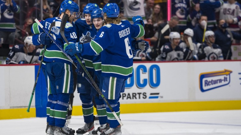 Nov 19, 2021; Vancouver, British Columbia, CAN; Vancouver Canucks forward Elias Pettersson (40) and  defenseman Oliver Ekman-Larsson (23) and forward Juho Lammikko (91) and forward Nils Hoglander (21) and  forward Brock Boeser (6) celebrate Ekman-Larsson s goal against the Winnipeg Jets in the first period at Rogers Arena. Mandatory Credit: Bob Frid-USA TODAY Sports