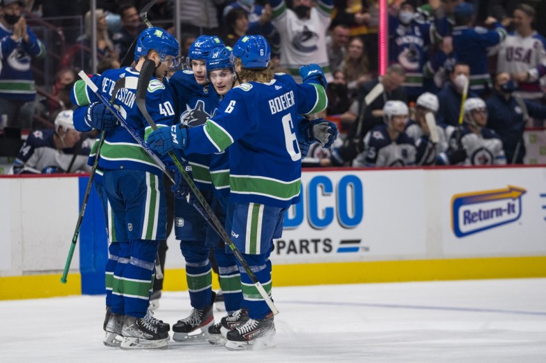 Nov 19, 2021; Vancouver, British Columbia, CAN; Vancouver Canucks forward Elias Pettersson (40) and  defenseman Oliver Ekman-Larsson (23) and forward Juho Lammikko (91) and forward Nils Hoglander (21) and  forward Brock Boeser (6) celebrate Ekman-Larsson s goal against the Winnipeg Jets in the first period at Rogers Arena. Mandatory Credit: Bob Frid-USA TODAY Sports