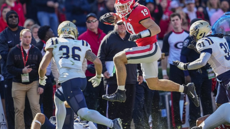 Nov 20, 2021; Athens, Georgia, USA; Georgia Bulldogs tight end Brock Bowers (19) jumps over Charleston Southern Buccaneers tacklers during the first quarter at Sanford Stadium. Mandatory Credit: Dale Zanine-USA TODAY Sports