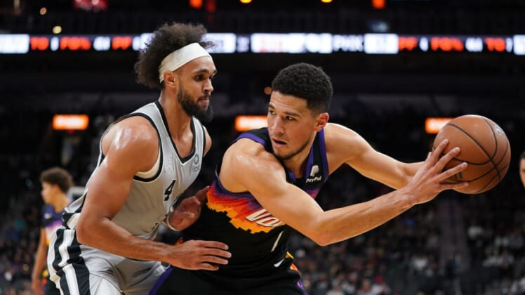Nov 22, 2021; San Antonio, Texas, USA;  Phoenix Suns guard Devin Booker (1) backs in to San Antonio Spurs guard Derrick White (4) in the first half at the AT&T Center. Mandatory Credit: Daniel Dunn-USA TODAY Sports