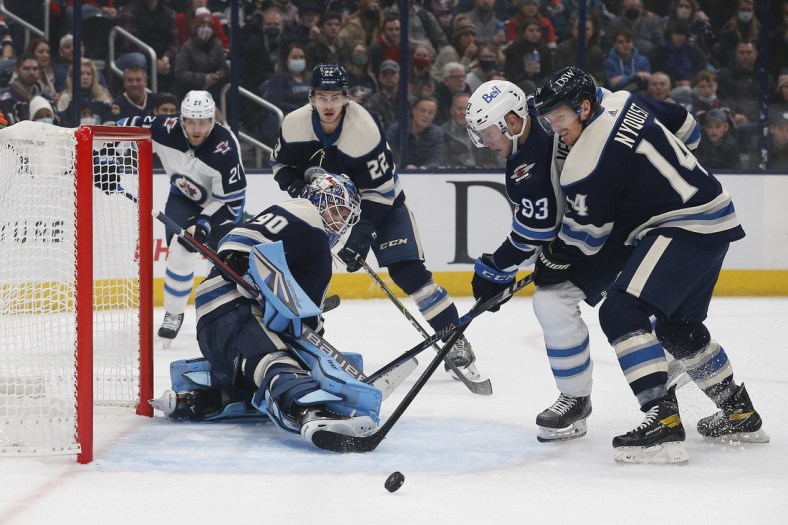 Nov 24, 2021; Columbus, Ohio, USA; Columbus Blue Jackets center Gustav Nyquist (14) keeps Winnipeg Jets left wing Kristian Vesalainen (93) from shooting a rebound of a goalie Elvis Merzlikins (90) save during the first period at Nationwide Arena. Mandatory Credit: Russell LaBounty-USA TODAY Sports