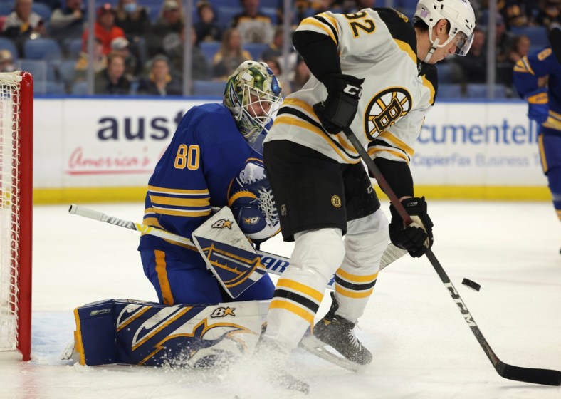 Nov 24, 2021; Buffalo, New York, USA;  Boston Bruins left wing Tomas Nosek (92) tries to deflect a shot on Buffalo Sabres goaltender Aaron Dell (80) during the first period at KeyBank Center. Mandatory Credit: Timothy T. Ludwig-USA TODAY Sports