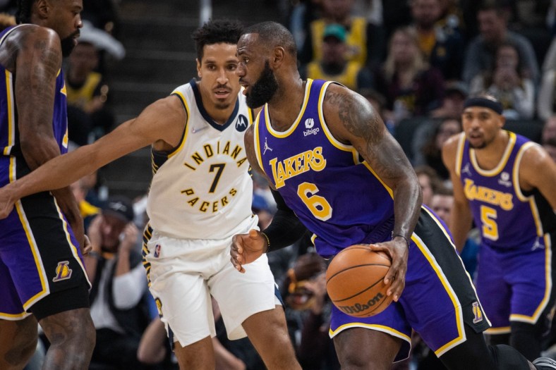 Nov 24, 2021; Indianapolis, Indiana, USA; Los Angeles Lakers forward LeBron James (6) dribbles the ball while Indiana Pacers guard Malcolm Brogdon (7) defends in the first half at Gainbridge Fieldhouse. Mandatory Credit: Trevor Ruszkowski-USA TODAY Sports