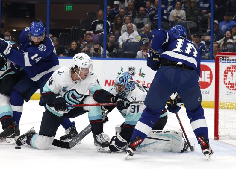 Nov 26, 2021; Tampa, Florida, USA;  Seattle Kraken defenseman Haydn Fleury (4) helps goaltender Philipp Grubauer (31) as Tampa Bay Lightning right wing Corey Perry (10) and left wing Pat Maroon (14) look for the rebound during the first period at Amalie Arena. Mandatory Credit: Reinhold Matay-USA TODAY Sports