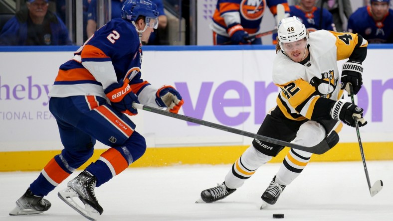 Nov 26, 2021; Elmont, New York, USA; Pittsburgh Penguins right wing Kasperi Kapanen (42) plays the puck against New York Islanders defenseman Robin Salo (2) during the first period at UBS Arena. Mandatory Credit: Brad Penner-USA TODAY Sports