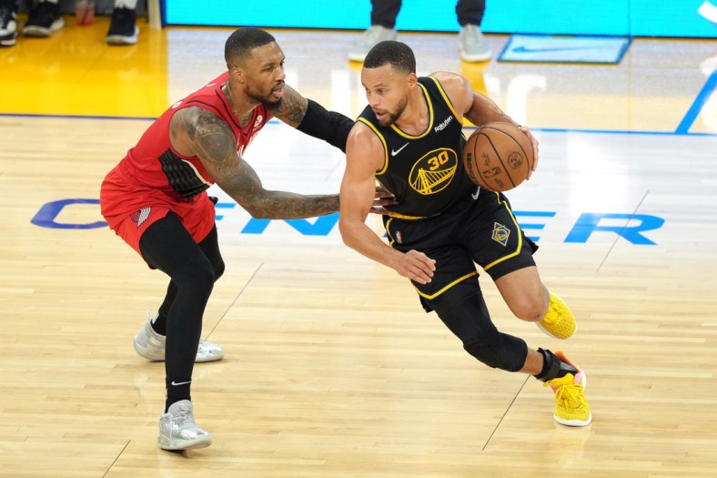 Nov 26, 2021; San Francisco, California, USA; Golden State Warriors guard Stephen Curry (30) dribbles while being defended by Portland Trail Blazers guard Damian Lillard (0) during the second quarter at Chase Center. Mandatory Credit: Darren Yamashita-USA TODAY Sports