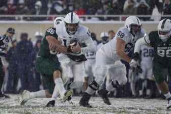 Nov 27, 2021; East Lansing, Michigan, USA; Penn State Nittany Lions quarterback Sean Clifford (14) gets wrapped up by Michigan State Spartans defensive end Drew Beesley (86) during the second quarter at Spartan Stadium. Mandatory Credit: Raj Mehta-USA TODAY Sports