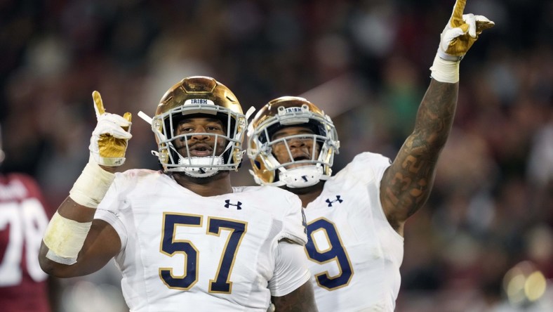 Nov 27, 2021; Stanford, California, USA; Notre Dame Fighting Irish defensive lineman Jayson Ademilola (57) celebrates with defensive lineman Justin Ademilola (9) after a sack during the third quarter against the Stanford Cardinal at Stanford Stadium. Mandatory Credit: Darren Yamashita-USA TODAY Sports