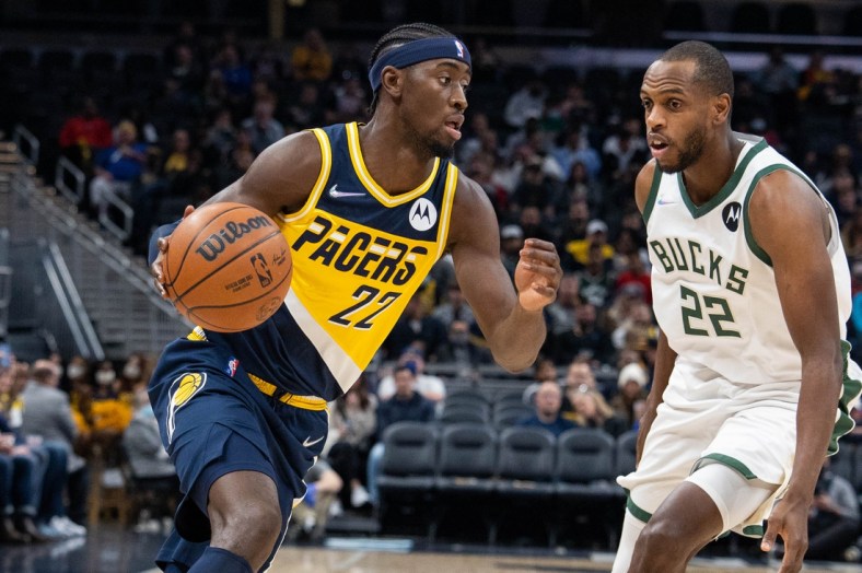 Nov 28, 2021; Indianapolis, Indiana, USA; Indiana Pacers guard Caris LeVert (22) dribbles the ball while Milwaukee Bucks forward Khris Middleton (22) defends in the first quarter at Gainbridge Fieldhouse. Mandatory Credit: Trevor Ruszkowski-USA TODAY Sports