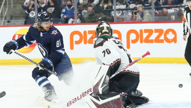 Nov 29, 2021; Winnipeg, Manitoba, CAN;  Winnipeg Jets forward Kyle Connor (81) watches the puck go past Arizona Coyotes goalie Kyle Capobianco (70) during the second period at Canada Life Centre. Mandatory Credit: Terrence Lee-USA TODAY Sports