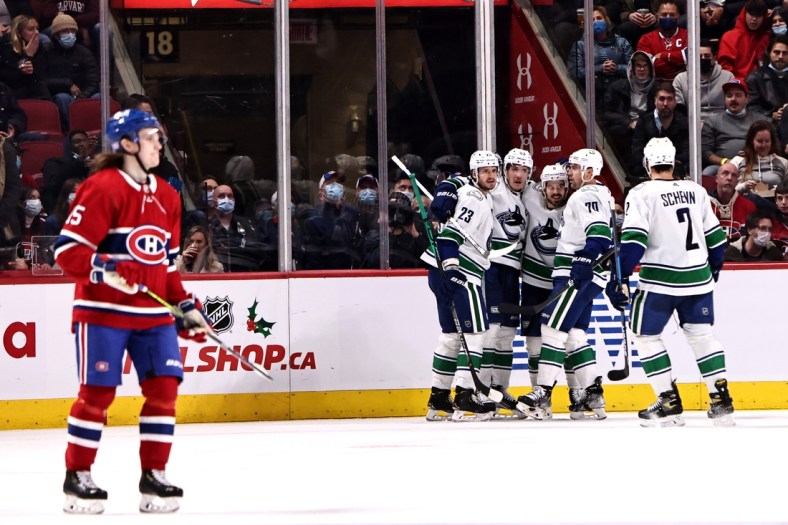 Nov 29, 2021; Montreal, Quebec, CAN; Vancouver Canucks right wing Conor Garland (8) celebrates his goal against Montreal Canadiens with teammates during the second period at Bell Centre. Mandatory Credit: Jean-Yves Ahern-USA TODAY Sports