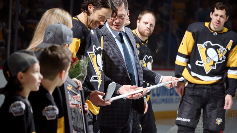 Mar 5, 2019; Pittsburgh, PA, USA;  Pittsburgh Penguins assistant general manager Bill Guerin (RC) presents center Matt Cullen (7) with an aluminum stick to commemorate Cullen's 1,500th career NHL game played before the game against the Florida Panthers at PPG PAINTS Arena. Mandatory Credit: Charles LeClaire-USA TODAY Sports