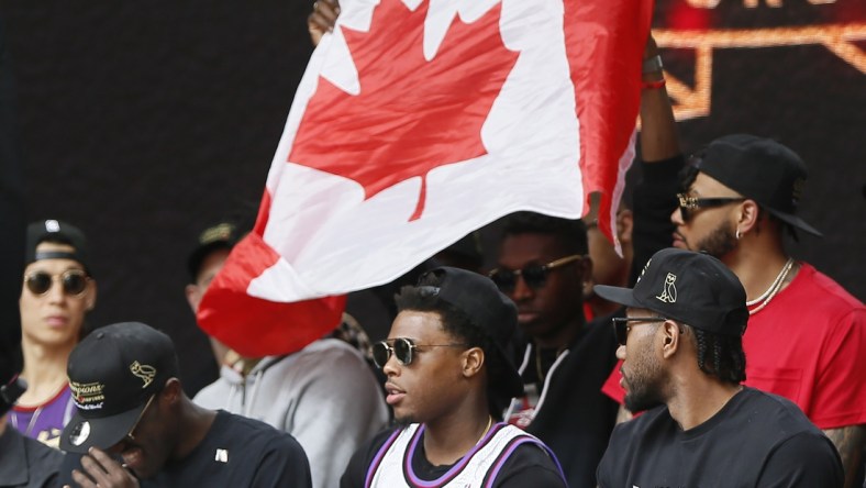 Jun 17, 2019; Toronto, Ontario, Canada; A Canadian flag is held behind Toronto Raptors guard Kyle Lowry (7) during a rally at Nathan Phillips Square. Mandatory Credit: John E. Sokolowski-USA TODAY Sports