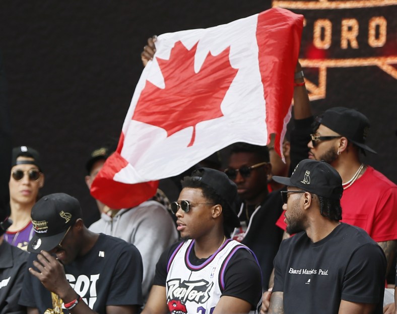 Jun 17, 2019; Toronto, Ontario, Canada; A Canadian flag is held behind Toronto Raptors guard Kyle Lowry (7) during a rally at Nathan Phillips Square. Mandatory Credit: John E. Sokolowski-USA TODAY Sports