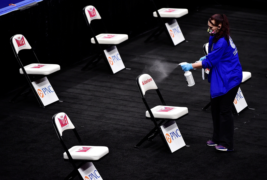 Mar 5, 2021; St. Louis, Missouri, USA; Staff spray and wipe down chairs near the court after the quarterfinals game of the Missouri Valley Conference Tournament between the Drake Bulldogs and the Northern Iowa Panthers at Enterprise Center was cancelled.  Mandatory Credit: Jeff Curry-USA TODAY Sports